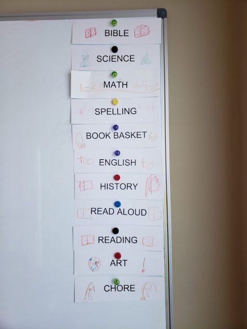 Homeschool Routine cards on a magnetic white board