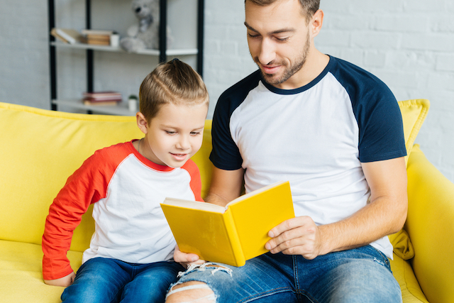 Homeschool kid reading to dad as part of temporary homeschool routine